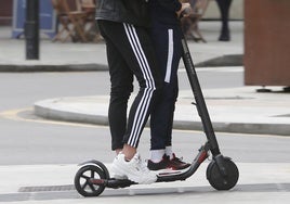 Dos personas circulan a bordo de un patinete eléctrico, en imagen de archivo.