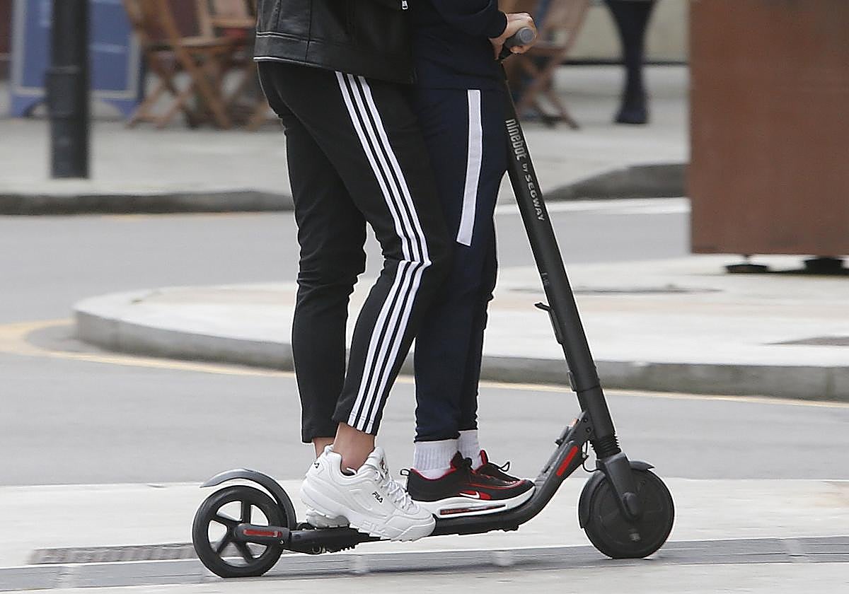 Dos personas circulan a bordo de un patinete eléctrico, en imagen de archivo.
