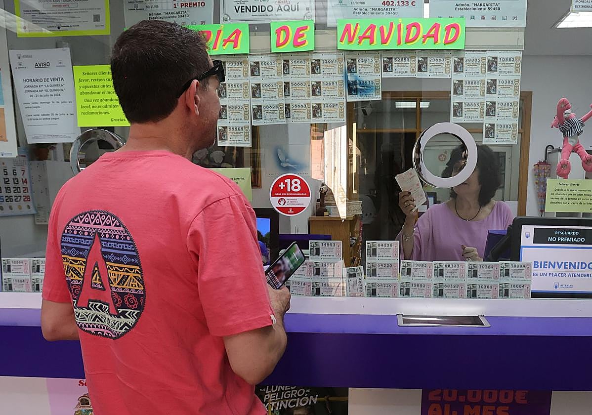 Una lotera atiende a un hombre en una administración de la capital.