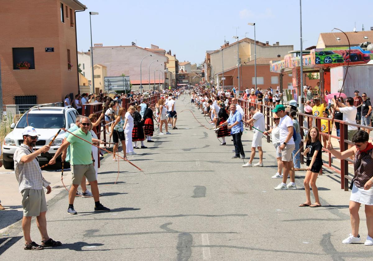 Dos filas de personas, una a cada lado de la carretera de Sebúlcor en Cantalejo, se preparan con sus trallas para el récord.