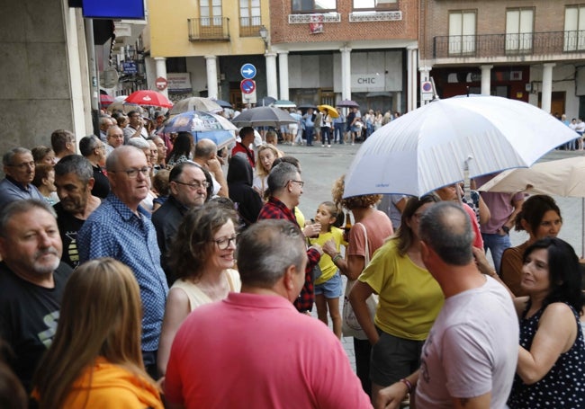 Los asistentes al acto refugiándose de la lluvia poco antes de que comenzase a desarrollarse.