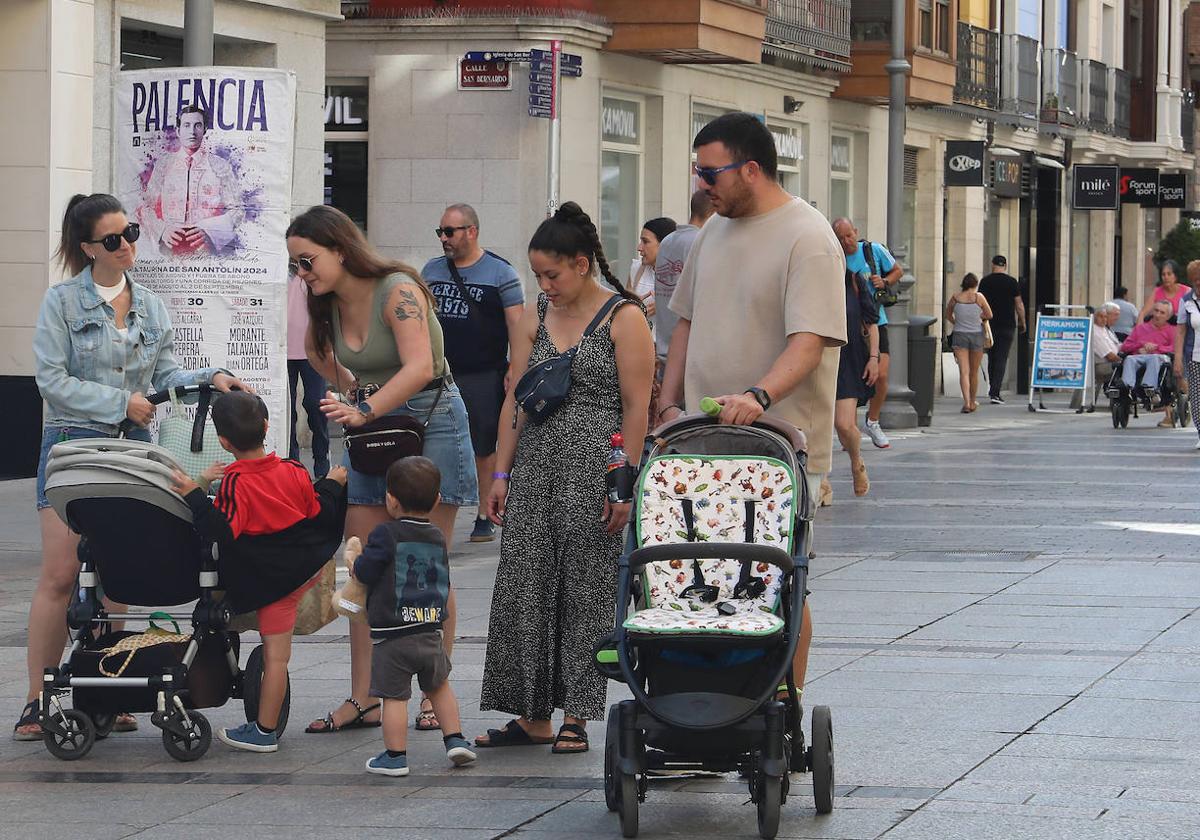 Familias con niños pequeños se saludan en la Calle Mayor de Palencia.