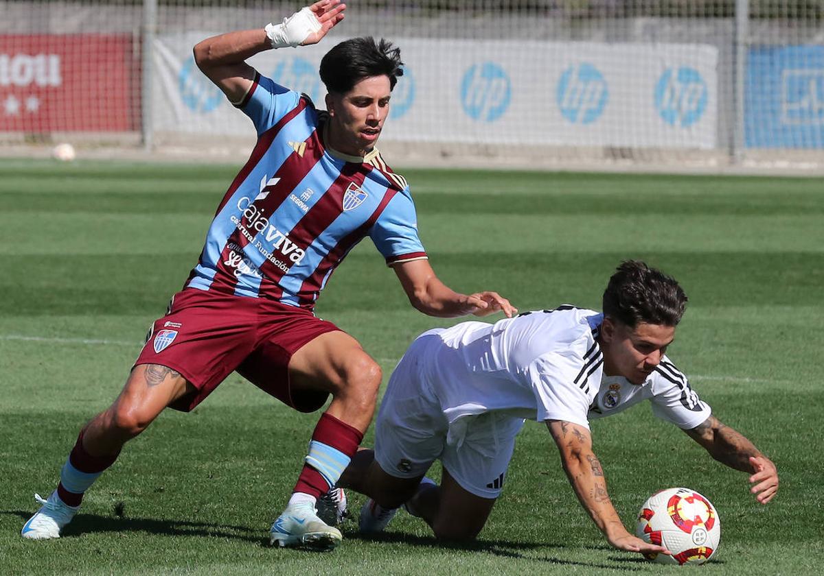 Fernán intenta llevarse la pelota ante un jugador del Castilla.