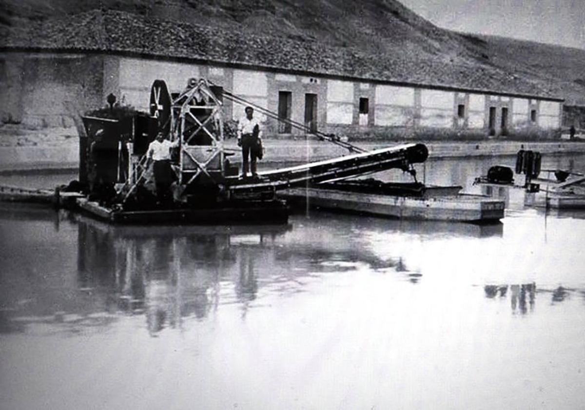 Imagen principal - Foto 1: Tareas de limpieza y dragado en el canal. Foto 2: Panorámica del barrio de la Victoria y de la dársena del Canal de Castilla, con las instalaciones fabriles, avanzado el siglo XX. Foto 3: Imagen estereoscópica de la dársena en los años 20 del siglo XX. 4,7, 6