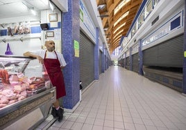 José Domínguez en su carnicería junto al pasillo vacío.