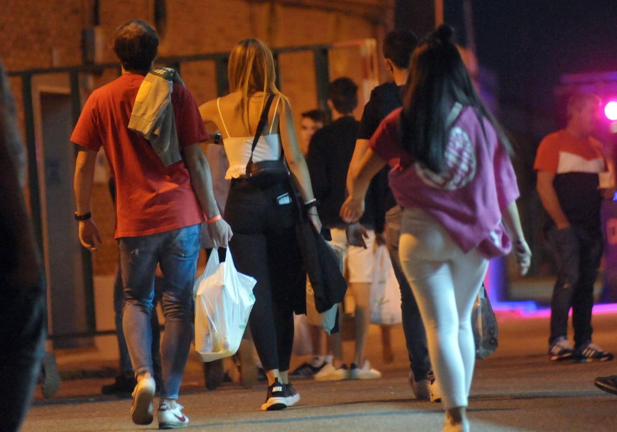 Peñistas y visitantes acuden a la verbena con sus bolsas.