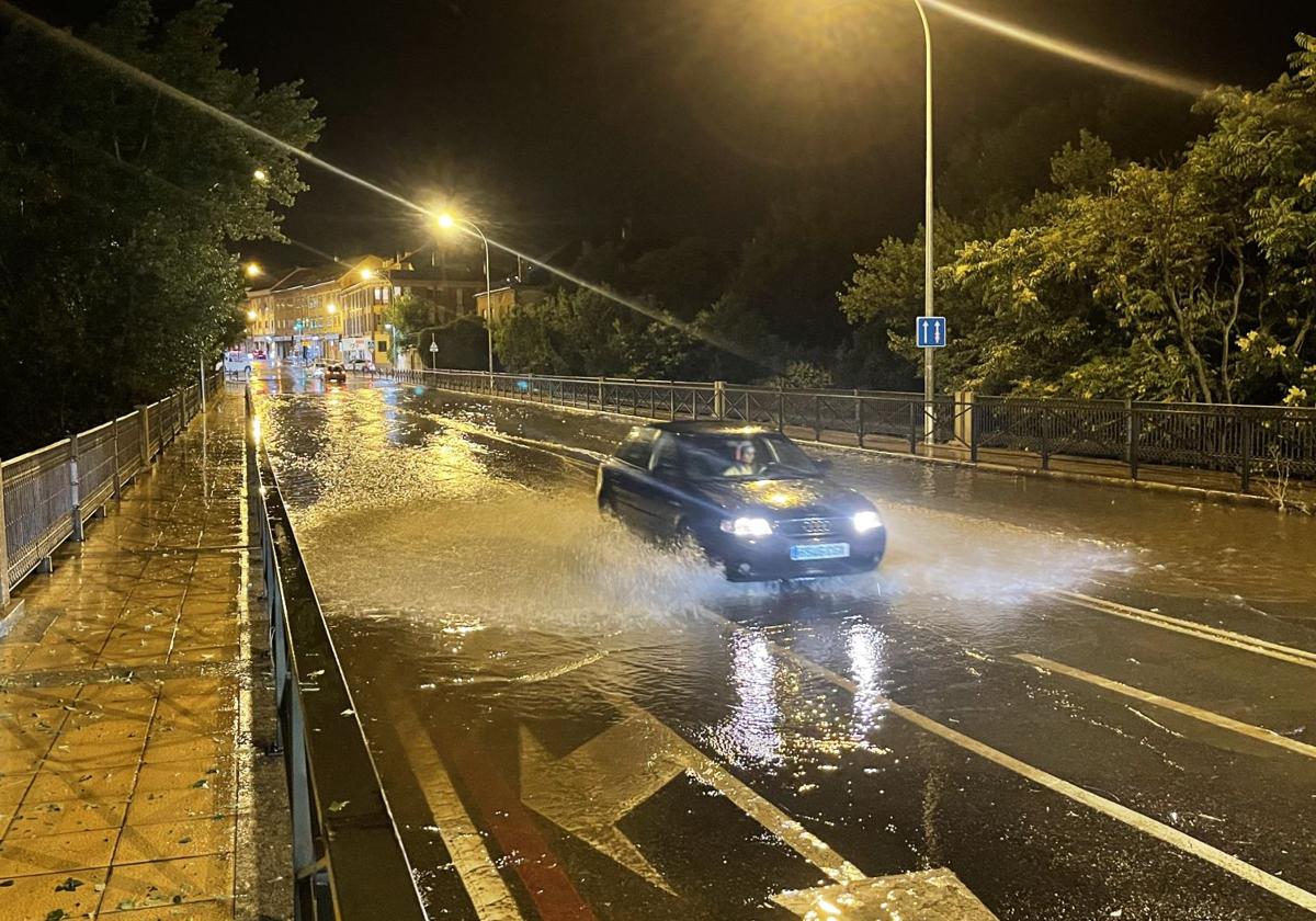 Un coche atraviesa una balsa de agua en el puente sobre el Eresma de Vía Roma.