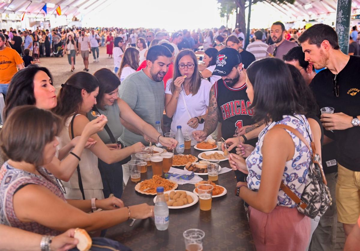 Un grupo de jóvenes disfruta de unas raciones en la Feria de Gastronomía, este domingo al mediodía.