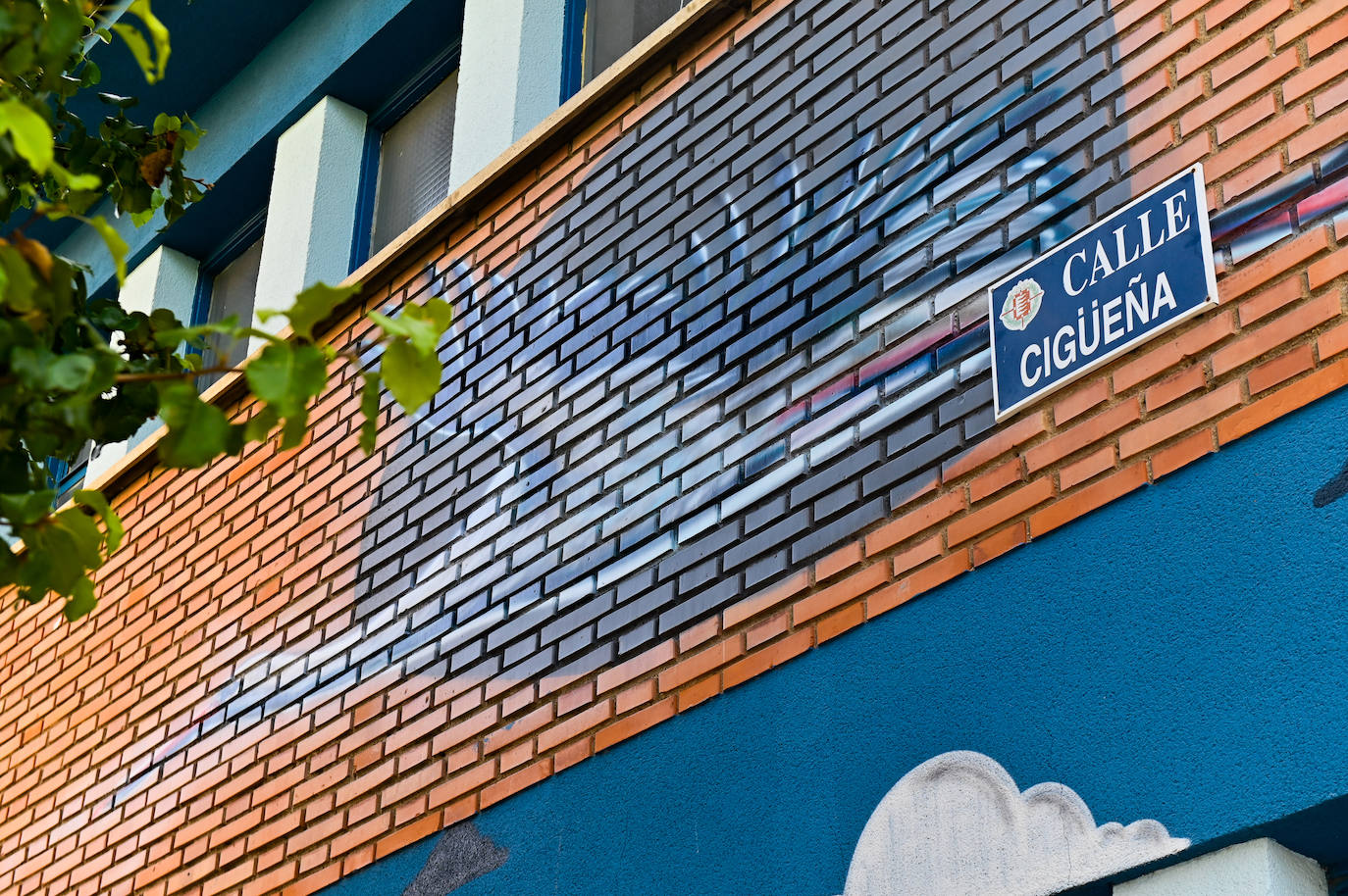 Cigüeña sobre el letrero de la calle del mismo nombre.