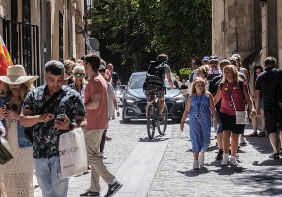 Peatones, bicicletas y coches circulan por la calle Daoiz.