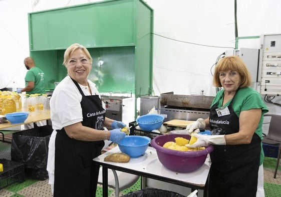 Dos voluntarias preparando los platos más típicos de la caseta de Andalucía