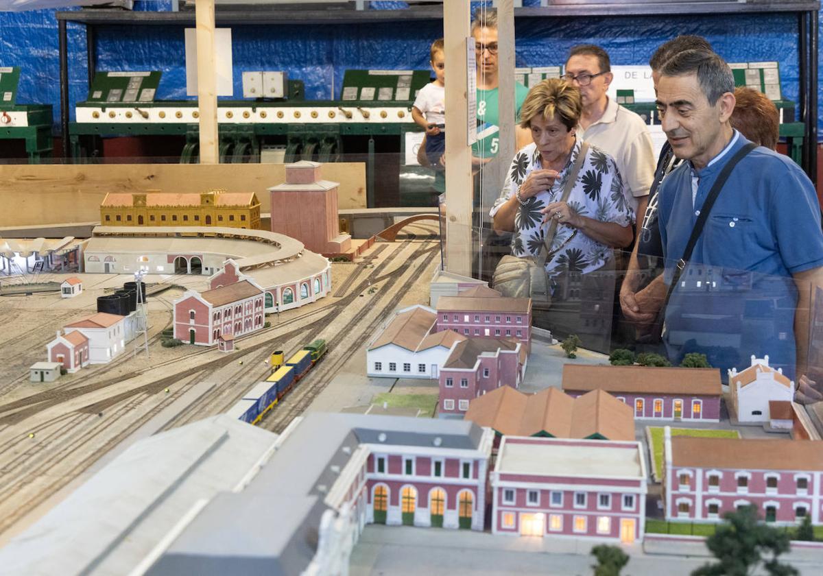 Algunos de los asistentes observan la maqueta de la Estación de Valladolid Campo Grande, con el Arco de Ladrillo al fondo.