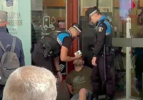 Agentes de la Policía Local reducen al ladrón en la puerta de Carrefour de la calle Santiago.