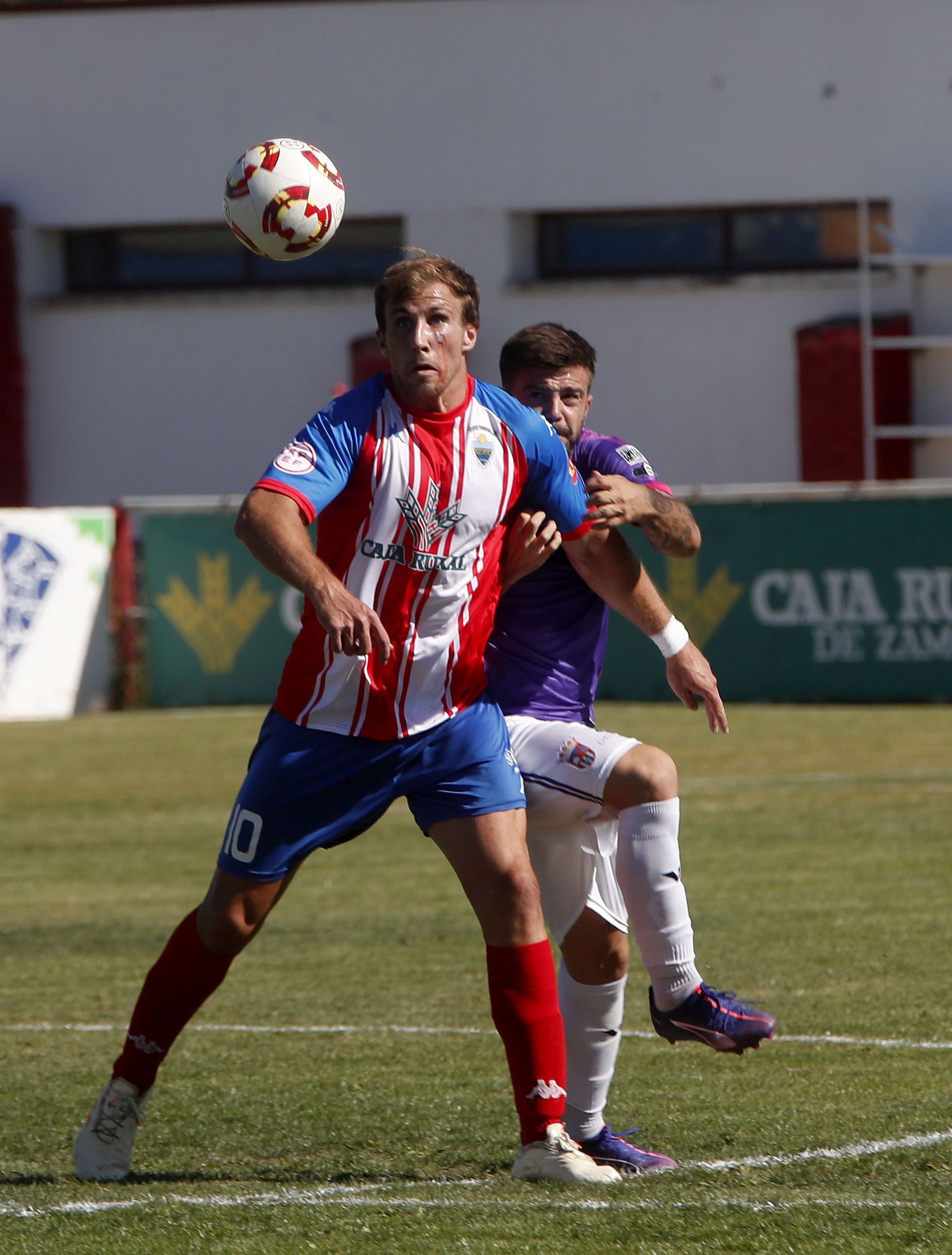 El atlético Chatún trata de rematar, presionado por el palentino Emilio.