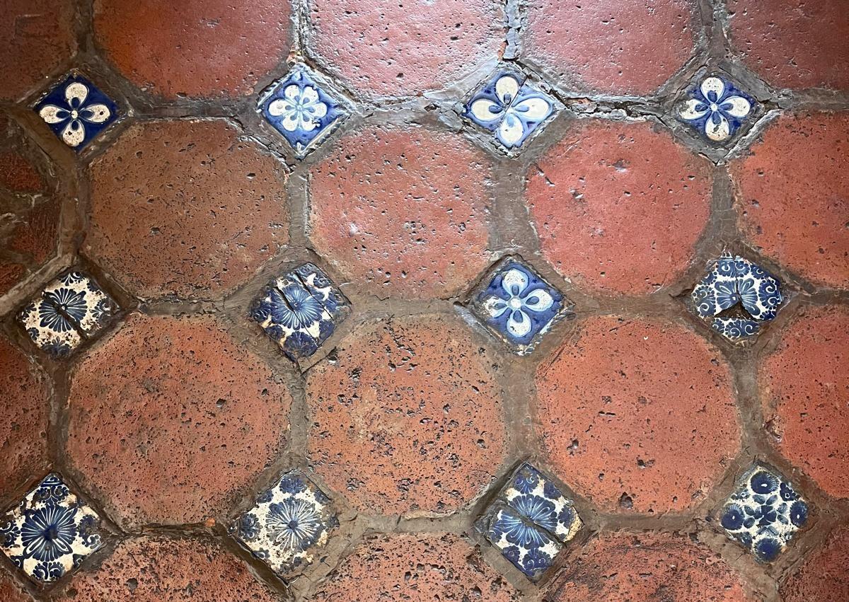 Imagen secundaria 1 - Estanterías de la biblioteca palafoxiana. El suelo de azulejos, una de las diferencias con la vallisoletana, y la virgen de Trapani. 