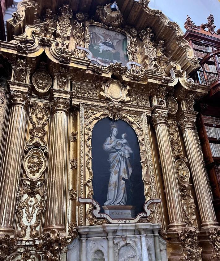 Imagen secundaria 2 - Estanterías de la biblioteca palafoxiana. El suelo de azulejos, una de las diferencias con la vallisoletana, y la virgen de Trapani. 