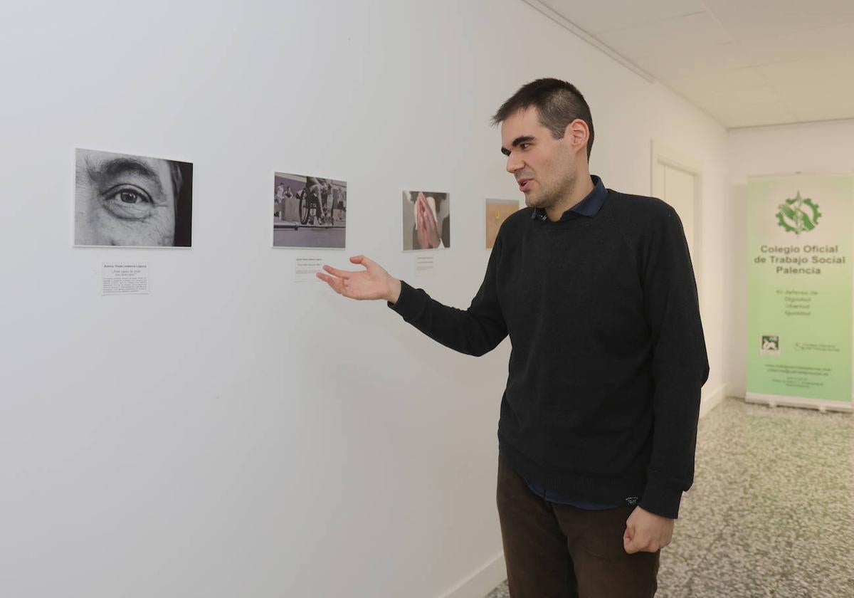 Miguel Sastre muestra las fotografías de una exposición del Colegio de Trabajo Social en la sede de la AECC.