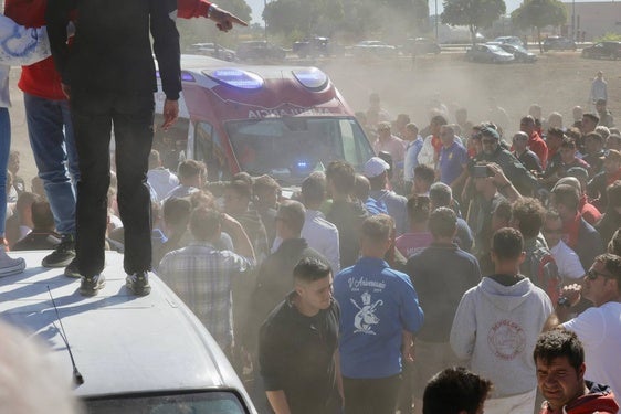 Espectadores en torno a la ambulancia de Cruz Roja antes de trasladar al segundo herido.