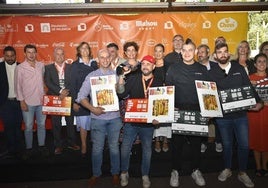 El primer premio levanta la estatuilla del Cristo, a la derecha, los dos cocineros de Flamma Valladolid, y a la izquierda, el tercera galardonado, en una foto de familia con organizadores y patrocinadores.