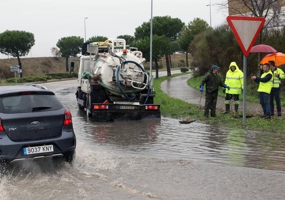 Operarios trabajan con un camión de saneamiento para drenar un embolsamiento de agua tras una tormenta.