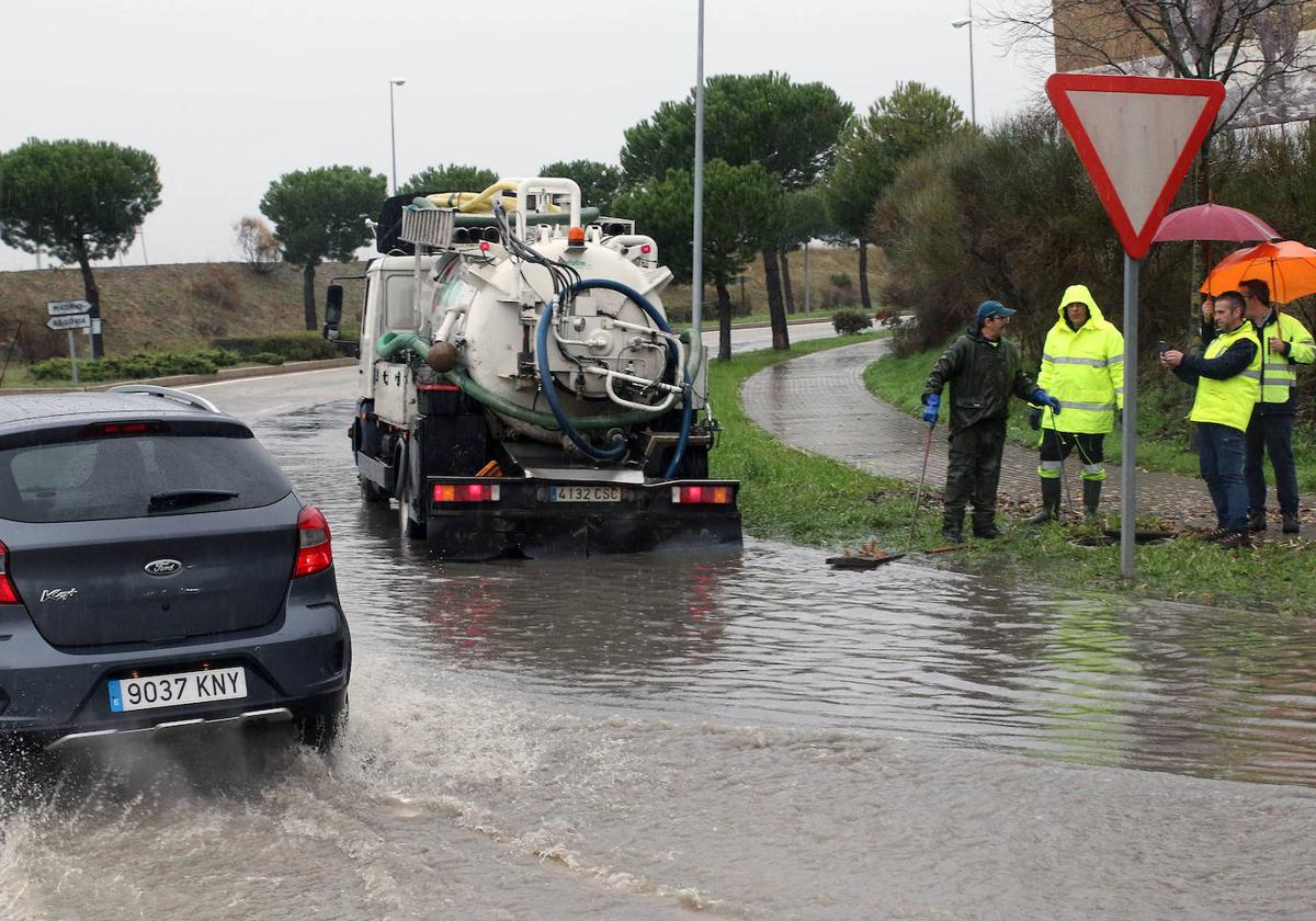 Operarios trabajan con un camión de saneamiento para drenar un embolsamiento de agua tras una tormenta.