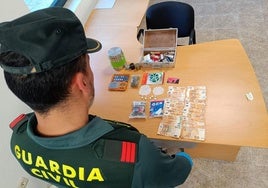 Un guardia civil de Segovia muestra la droga y el dinero intervenidos en una operación.