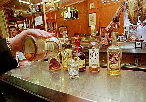 Un camarero sirve una copa en un bar.