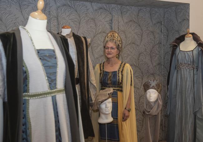 La diseñadora Carmen Andueza posa con algunos de los vestidos medievales de exposición.