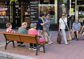 Varias personas pasean y descansan en la avenida de Palencia de Valladolid.