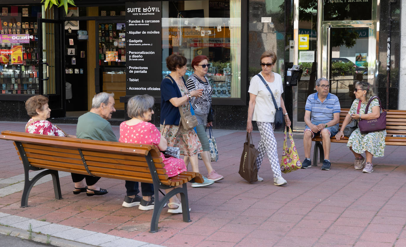 Varias personas pasean y descansan en la avenida de Palencia de Valladolid.