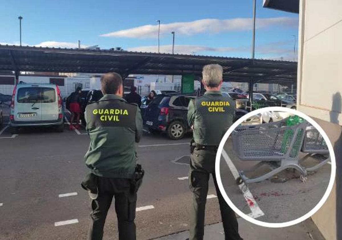 Dos agentes custodian el supermercado tras los hechos. En el círculo, restos de sangre tras la reyerta.