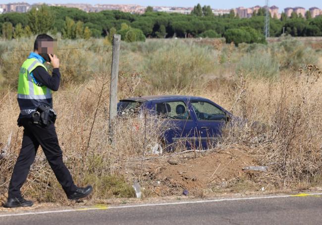 El turismo siniestrado, al borde de la calzada de la carretera de las Arcas Reales, por donde fue trasladado el cuerpo de la víctima en una imagen tomada con posterioridad al incidente con los agentes.