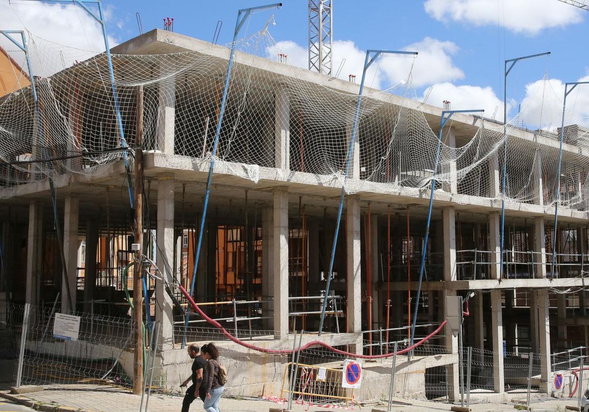 Dos personas pasean junto a una promoción de obra nueva en la ciudad de Segovia.