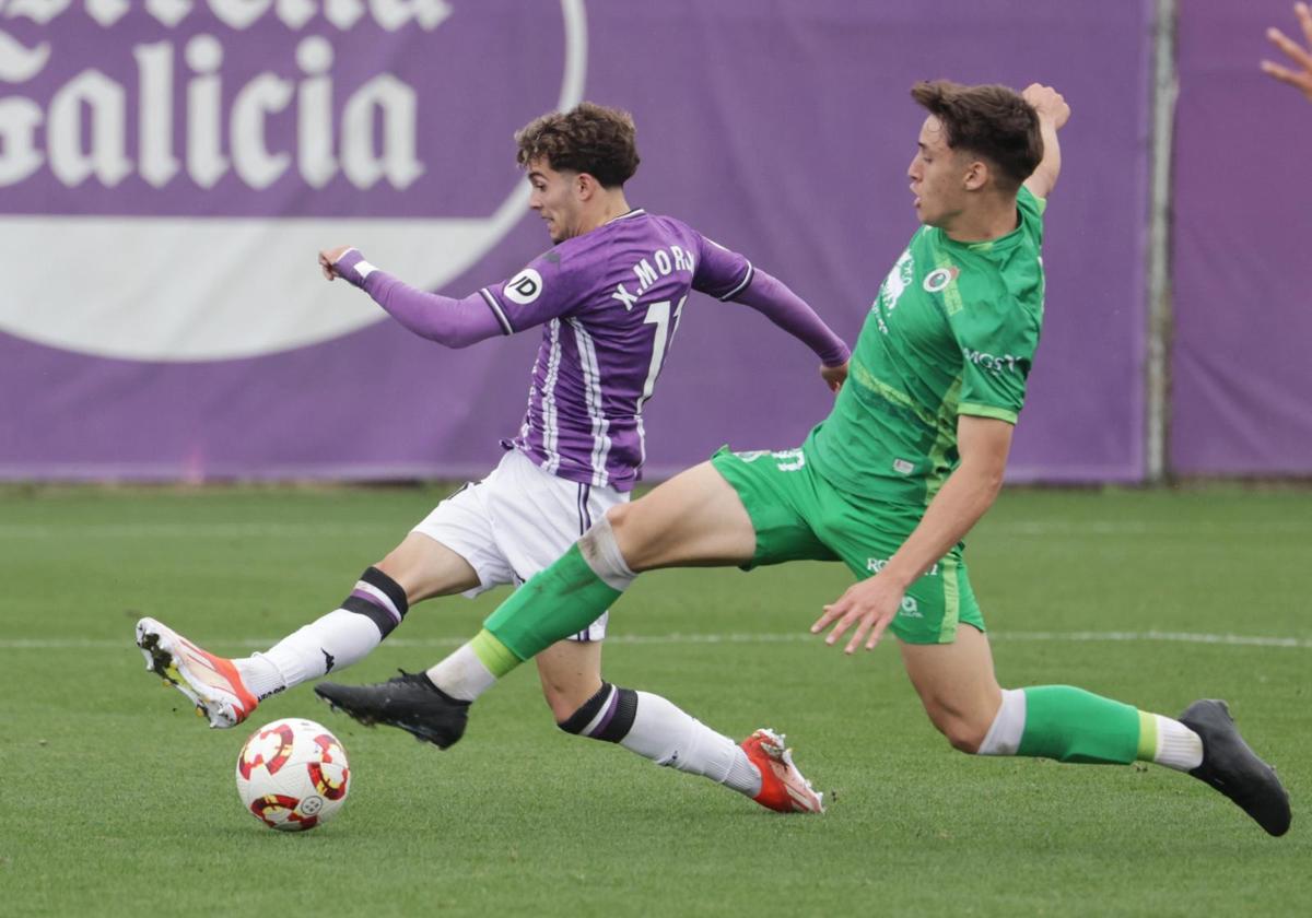 Xavi Moreno remata ante un rival durante el Real Valladolid Promesas-Rayo Cantabria de este domingo en los Anexos.