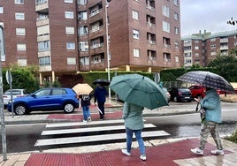 Los viandantes se protegen de la lluvia con paraguas en Parquesol.