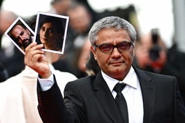 Mohammad Rasoulof, en el pasado Festival de Cannes, con los retratos de sus actores.