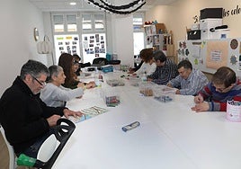 Usuarios de la asociación trabajan en un taller en la sede, situada en la calle Ramírez.