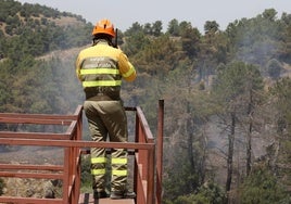 Un efectivo participante en la extinción de un incendio vigila el fuego.