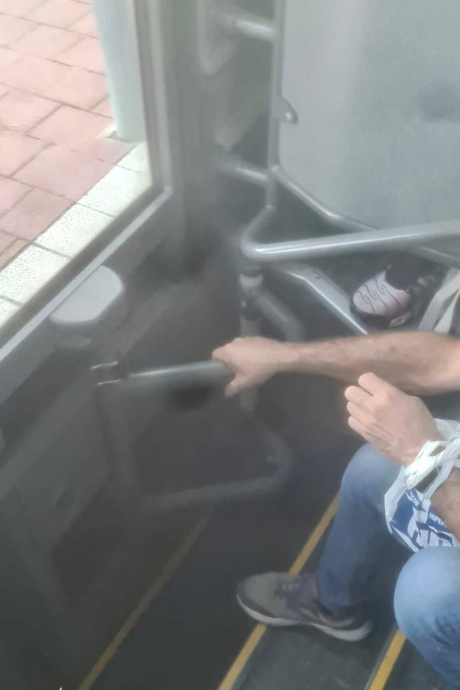 Usuario agarrando la puerta del autobús mientras circula