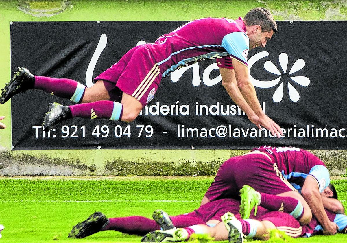 Manu se lanza sobre los jugadores de la Segoviana que celebraban uno de los goles ante el Real Unión, este domingo.