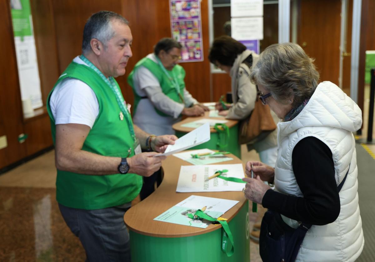 Varios voluntarios recogen inscripciones para la Marcha contra el Cáncer, en la oficina para apuntarse habilitada en la calle Menéndez Pelayo.