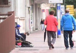 Una persona sin recursos pide ayuda junto a la plaza de España.