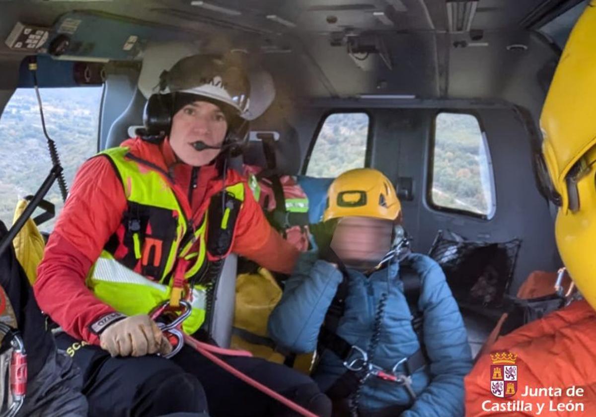 La senderista herida, sentada, en el interior de helicóptero durante el traslado.