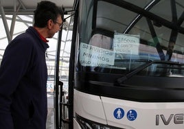 Un hombre observa un cartel que anuncia los servicios mínimos por la huelga en una línea de autobús de Segovia.