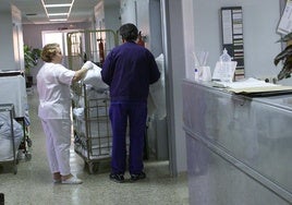 Imagen de archivo de una técnico en cuidados de enfermería repartiendo ropa de cama y aseo en un hospital.