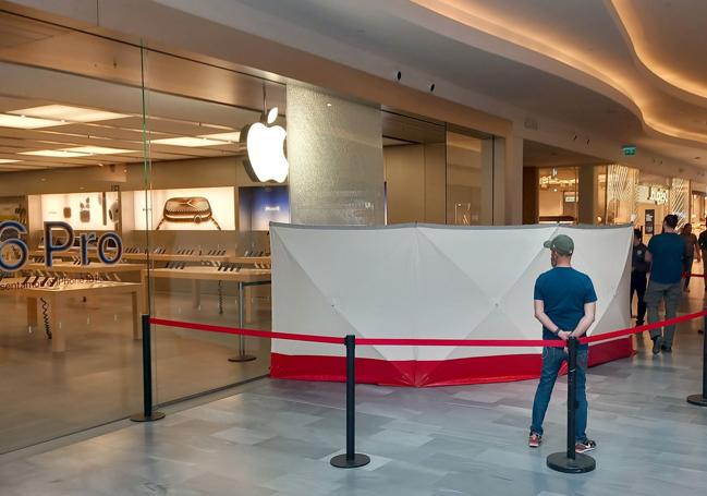 Mampara colocada en torno a la cristalera rota de la tienda desvalijada de Apple tras el asalto del sábado.