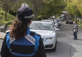 Una agente de la Policía Local controla el tráfico de acceso al cementerio.