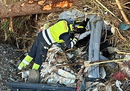 Un bombero de la Diputación de Valladolid inspecciona el interior de un vehículo tras los efectos de la DANA.