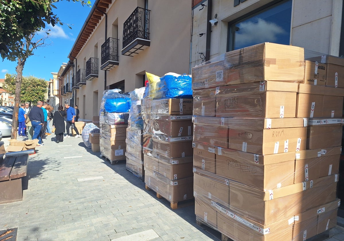 Algunos de los palés de ropa y otros productos recogidos en la acera de la autoescuela.