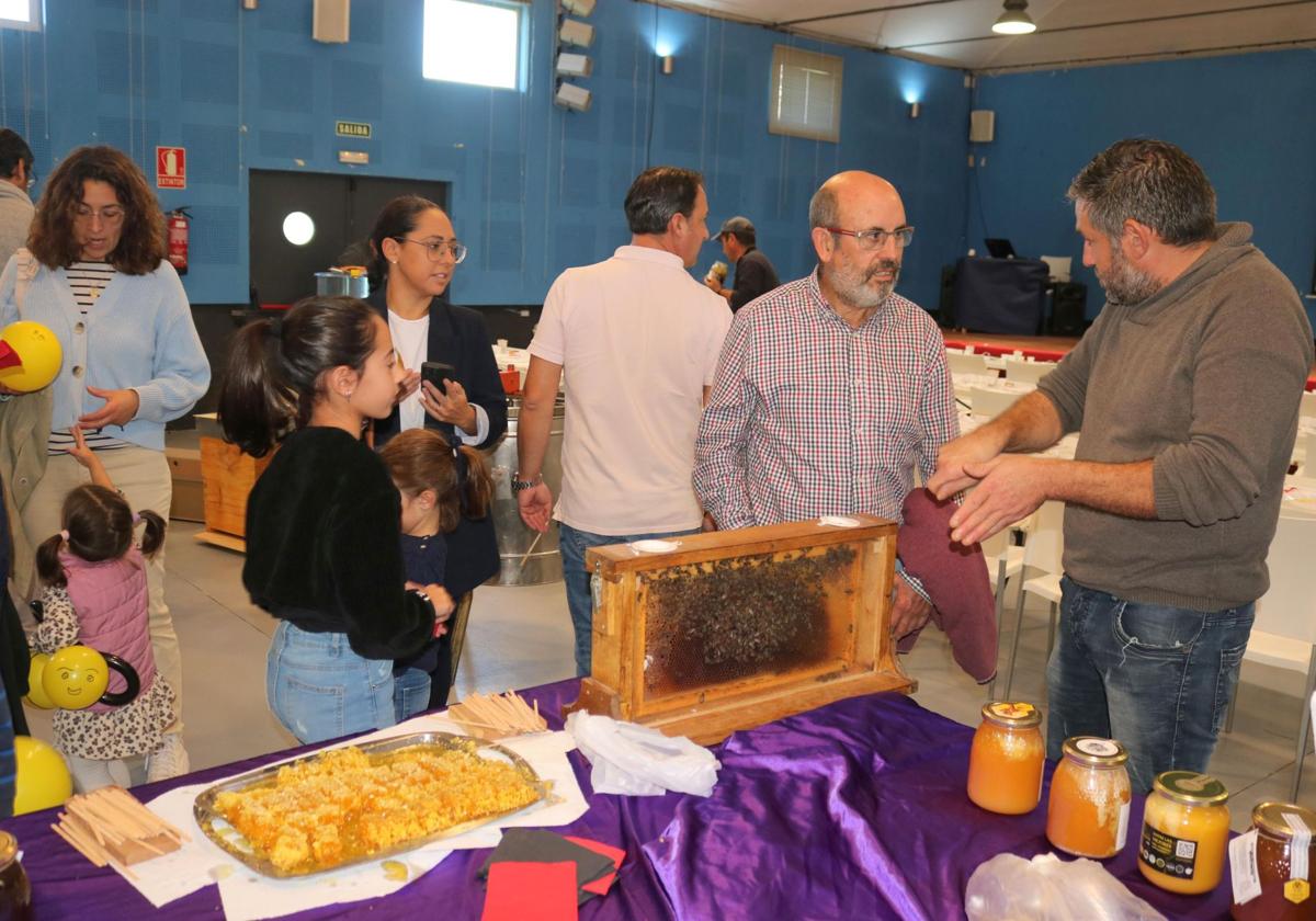 El apicultor local Víctor Román, a la derecha, explica el trabajo de elaboración de la miel.